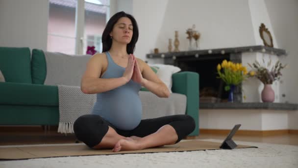 Домашняя медитация для будущей матери - беременной женщины в глубоком застое на полу в гостиной, с уделением приоритетного внимания психическому здоровью и умственному развитию - Кадры, видео