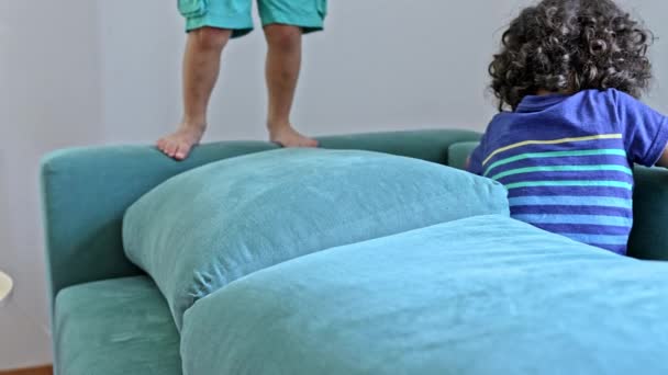 Tappaminen ikävystyminen - pienet pojat pelata hyppäämällä sohvalla - Materiaali, video