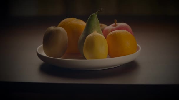 Блюдо свежих фруктов отображается на столе, демонстрируя натуральные продукты в качестве вкусного и здорового варианта закуски. Красочные продукты делает для красивой и аппетитной центральной фигурой - Кадры, видео