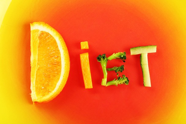 Word DIET made of sliced vegetables on color plate background - Foto, afbeelding