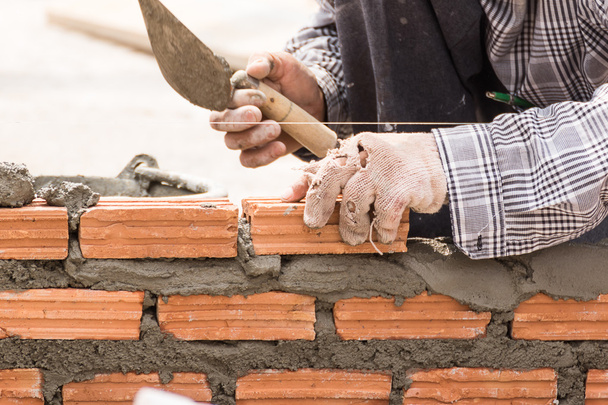 Bir tuğla duvar inşaat sitesinde çalışıyor çimento - Fotoğraf, Görsel