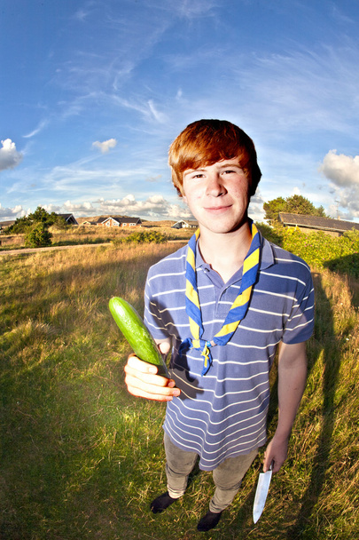 jongen met mes en komkommer - Foto, afbeelding
