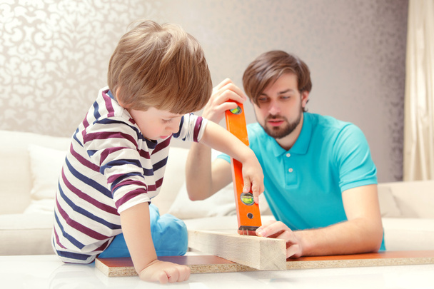 Father and son play with a building kit - 写真・画像