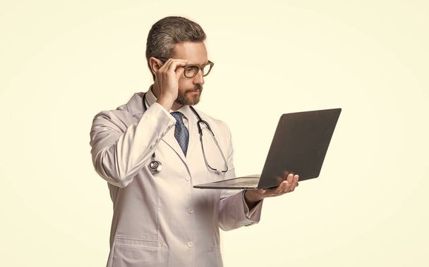 photo of busy emedicine and doctor man with laptop. doctor promoting emedicine isolated on white. doctor offering emedicine in studio. doctor presenting emedicine on background. - Fotografie, Obrázek
