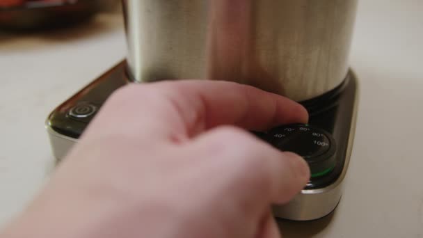 Z pragnieniem ciepłego napoju osoba zaczyna czajnik elektryczny, sprawność czajnik elektryczny i nowoczesny design, aby szybko podgrzewać wodę ułatwiając przygotowanie herbaty lub kawy z czajnikiem elektrycznym - Materiał filmowy, wideo