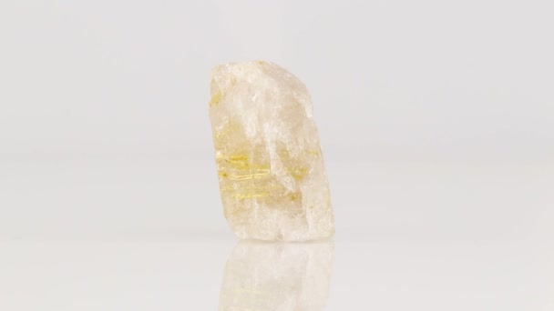Στιλβωμένη ορυκτή πέτρα Rutile σε χαλαζία σε zoisite περιστρέφεται σε έναν κύκλο σε λευκό φόντο γκρο πλαν - Πλάνα, βίντεο