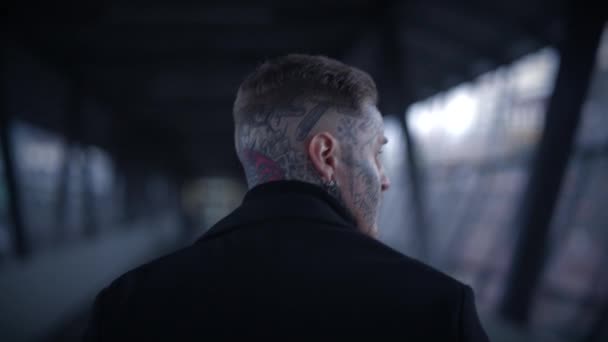 Татуированный мужчина, ищущий внимания, стоит на городской улице - Кадры, видео