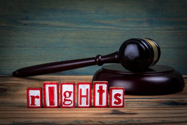 ПРАВА. Красные буквы алфавита и судьи молоток на деревянном фоне. Концепция законов и правосудия. - Фото, изображение