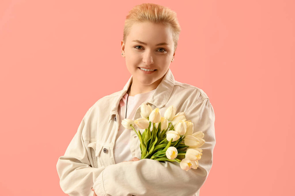 Молода жінка з тюльпанами на рожевому фоні
 - Фото, зображення