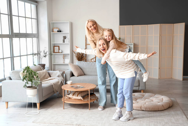 Cute little girl with her mother and granny having fun at home - Photo, Image