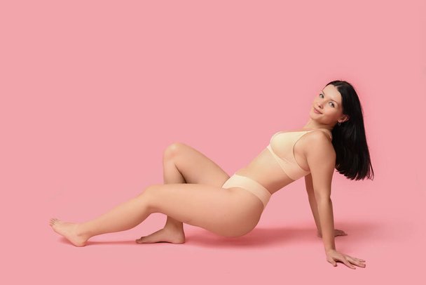 Body positive young woman in underwear smiling on pink background - Photo, Image
