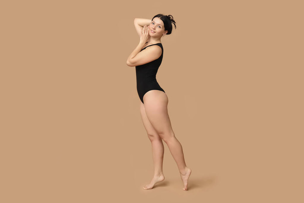 Body positive young woman on beige background - Valokuva, kuva
