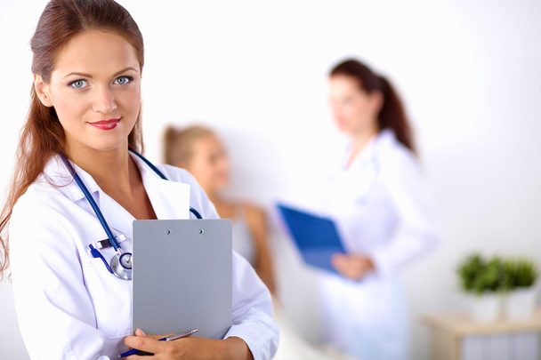 Smiling female doctor with a folder in uniform standing at hospital - Фото, зображення