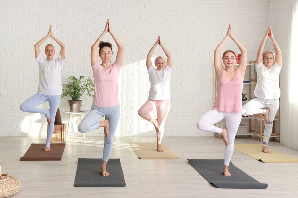 Group of mature women doing yoga in gym - Photo, Image