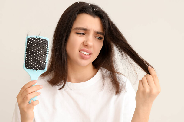 Preoccupato giovane donna con problema di perdita di capelli su sfondo bianco - Foto, immagini