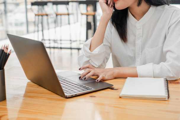 Profi nő kezét gépelés egy laptop mellett egy notebook, rögzíti a fókusz és a munkamorál. - Fotó, kép