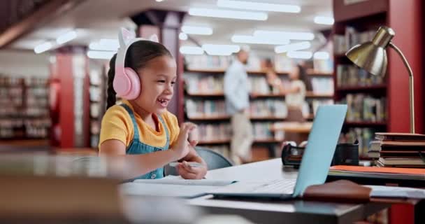 Laptop, rozmowy wideo i dziecko w szkole online, elearning i wzrost rozwoju, dziewczyna i student. Słuchawki, internet i dziecko piszące do edukacji na biurku biblioteki, papieru i testu. - Materiał filmowy, wideo