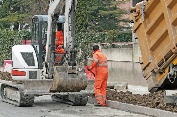 Lavoratori con la tuta e un bulldozer per lavorare in una costruzione stradale si
 - Foto, immagini