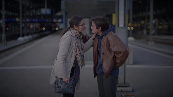 Reunión de madre soltera e hijo adolescente abrazándose en la plataforma ferroviaria  - Metraje, vídeo