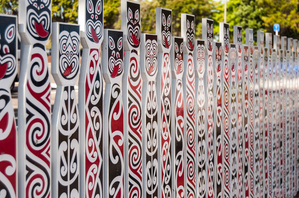Valla con rostros tradicionales maoríes
 - Foto, Imagen