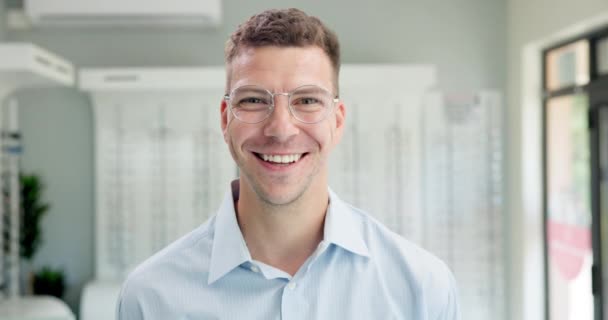 Gelukkig, optometrist en gezicht van de man met bril in petto voor visie, oogverzorging en gezondheid. Glimlach, oogheelkunde en portret van mannelijke klanten met brillen of brillen voor wellness in de optische winkel - Video