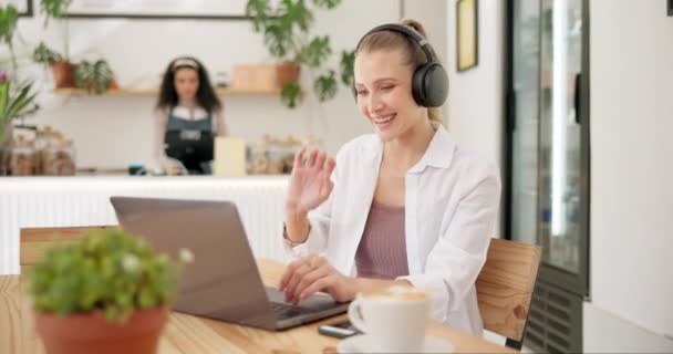 Ακουστικά, υπολογιστής και γυναίκα σε βιντεοκλήση σε καφέ με φλιτζάνι καφέ για online webinar. Τεχνολογία, καπουτσίνο και γυναικεία δημιουργική freelancer σε εικονική συνάντηση με φορητό υπολογιστή στο εστιατόριο - Πλάνα, βίντεο