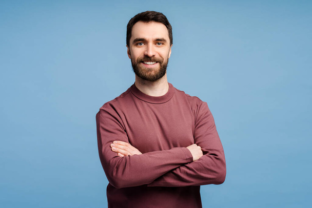 Handsome smiling middle aged businessman, manager posing with arms crossed isolated on blue background. Successful business concept - Photo, Image
