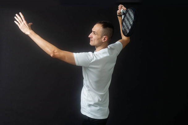 Padel Tenis oyuncusu ve Raket in Hands. Siyah arka planda kürek tenisi. Yüksek kalite fotoğraf - Fotoğraf, Görsel