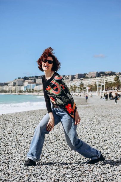 Beautiful girl with a silk scarf on the beach in Nice - Photo, Image