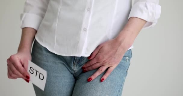 Mulher mostrando sinal std e segurando genitais com dor closeup filme 4k câmera lenta. Infecções sexualmente transmissíveis e conceito de doenças - Filmagem, Vídeo