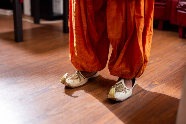 Ένα κοντινό πλάνο του περίτεχνα σχεδιασμένο ινδικό σάρι ύφασμα και παραδοσιακά υποδήματα jutti. - Φωτογραφία, εικόνα