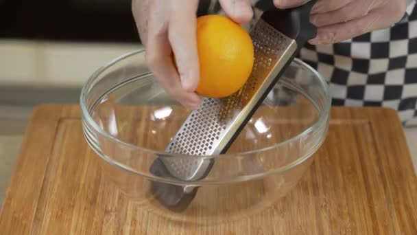 Kokki raastaa tuoretta appelsiininkuorta lähikuva - Materiaali, video
