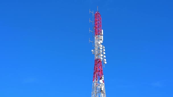 Cabo de San Antonio, Alicante - Spanien 12-05-2023: Blick auf einen rot-weißen Mobil- und Radarturm vor dem wolkenlosen blauen Himmel. Die verschiedenen Antennen sind gut sichtbar - Filmmaterial, Video