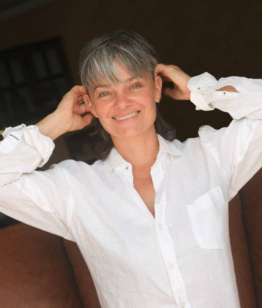 portrait of a mature woman in white shirt indoors - Photo, Image