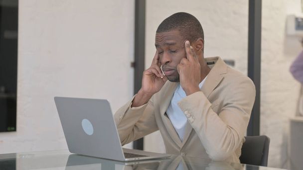 Afroamerikaner hat Kopfschmerzen, tippt auf Laptop - Foto, Bild