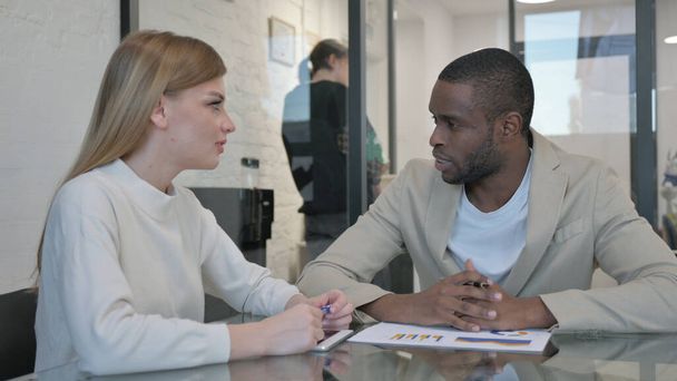 Молодий чоловік розмовляє під час зустрічі з жіночою колегою - Фото, зображення