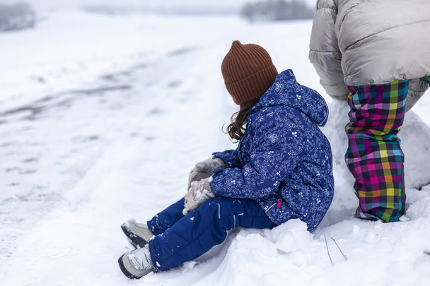 Carino bambina e sua madre giocare nella neve il giorno d'inverno - Foto, immagini