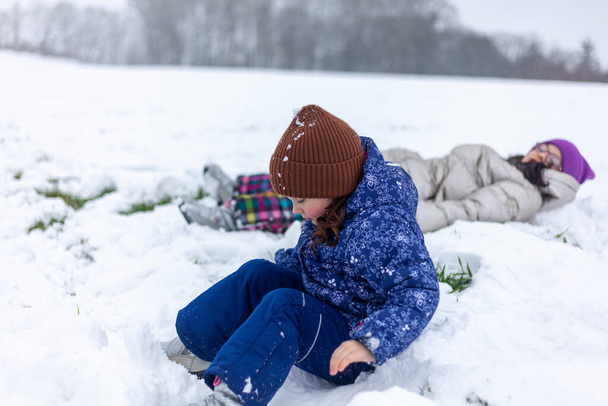 Kaksi pientä tyttöä leikkimässä lumessa. Talvi hauskaa lapsille. - Valokuva, kuva