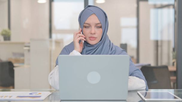 Mujer árabe hablando por teléfono en el trabajo - Foto, imagen