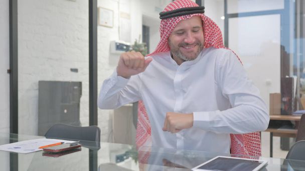 Glücklicher muslimischer Mann mittleren Alters tanzt im Büro - Foto, Bild