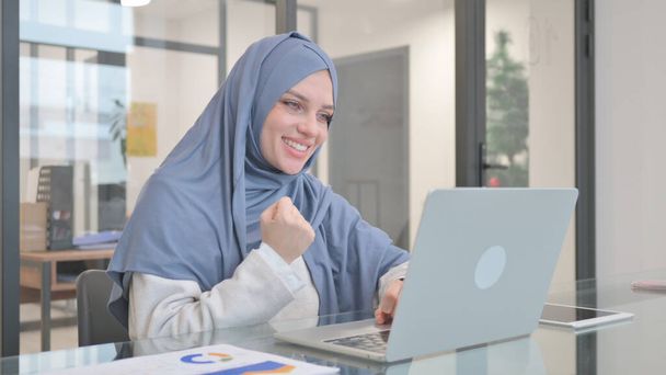 Kobieta w Hijab świętuje sukces na laptopie - Zdjęcie, obraz