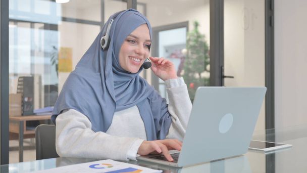 Femme dans Hijab avec casque parlant en ligne dans le centre d'appels - Photo, image