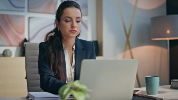 Closeup diligent businesswoman typing laptop keyboard in office. Meticulous professional manager focused on task having digital work. Serious woman writing notes at notebook composing email indoors - Footage, Video