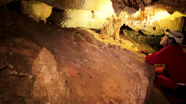 Grupa speleologów wewnątrz jaskini, oświetlona reflektorami, badająca głębie tajemniczego podziemnego systemu. Wysokiej jakości materiał 4k - Materiał filmowy, wideo
