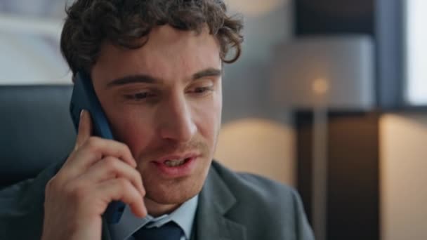 Bezorgde zakenman die telefoongesprekken voert op kantoor van dichtbij. Gestresste zakenman praat smartphone op de moderne werkplek het gevoel geïrriteerd. Zenuwachtige man wordt woedend op een telefoontje. - Video