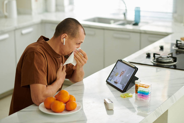 Kýchající muž video volá svého lékaře požádat o léčbu alergie - Fotografie, Obrázek