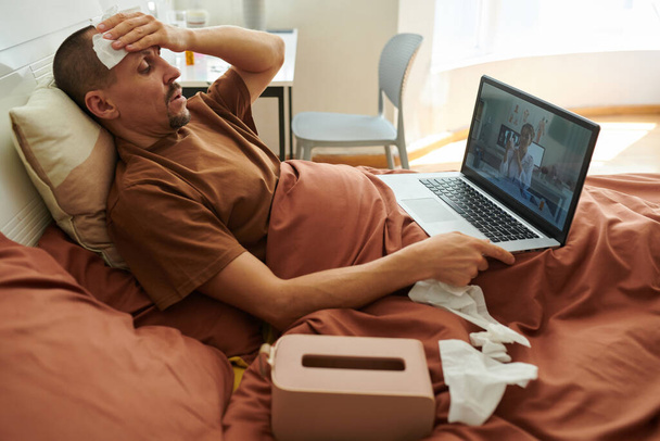 Zieke man lijdt aan koorts video bellen zijn arts - Foto, afbeelding