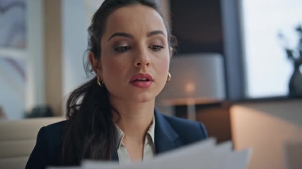 Serious businesswoman examining documents working office closeup. Calm busy specialist looking papers reading business contract at workplace. Brunette woman writing notes at notebook at light cabinet - Footage, Video