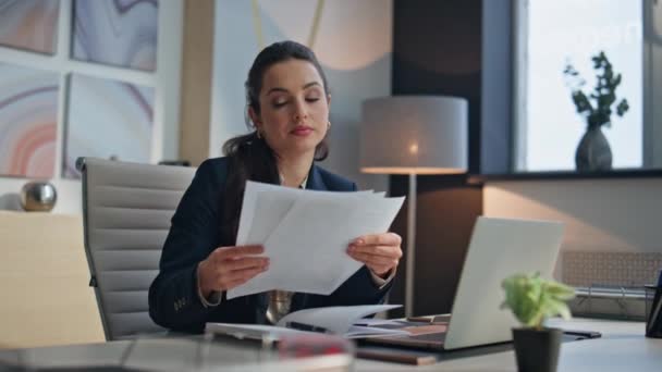 Tired lady study documents in creative office. Company lawyer executive examining papers checking contract at desk. Elegant exhausted businesswoman working alone reading financial report at workplace - Footage, Video