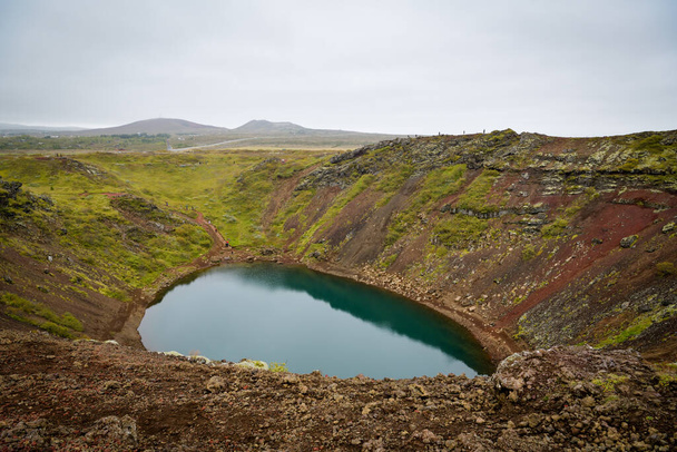 Kerid, Island - 4. September 2022: Touristen spazieren an bewölkten Tagen im September 2022 um den Kerid-Krater in Island - Foto, Bild